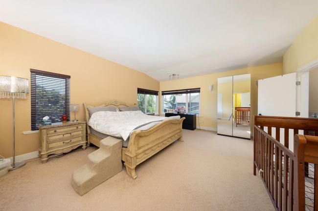 Bedroom featuring light carpet, vaulted ceiling, and baseboards | Image 26
