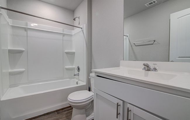 Full bath featuring visible vents, shower / washtub combination, toilet, vanity, and wood finished floors | Image 24