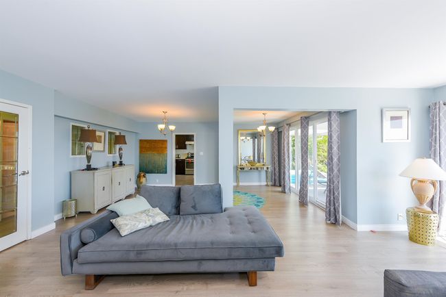Living room with a chandelier, wood finished floors, and baseboards | Image 10