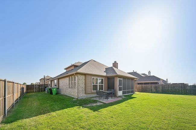 Back of house featuring a patio area, a yard, a fenced backyard, brick siding, and roof with shingles | Image 36