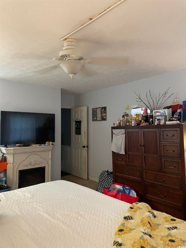 Carpeted bedroom featuring a fireplace and ceiling fan | Image 18