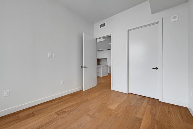 Unfurnished bedroom featuring baseboards, light wood finished floors, and visible vents | Image 8