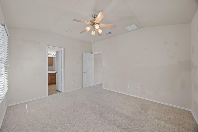 Unfurnished bedroom featuring light carpet, visible vents, and vaulted ceiling | Image 20