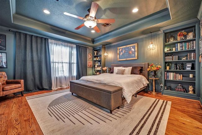 Spacious primary bedroom features moody tones that create a cozy and inviting atmosphere, includes the original hardwood floors that add warmth and character. (Please Note: Seller happy to accommodate buyer's if neutral or lighter paint desired for primary suite) | Image 25