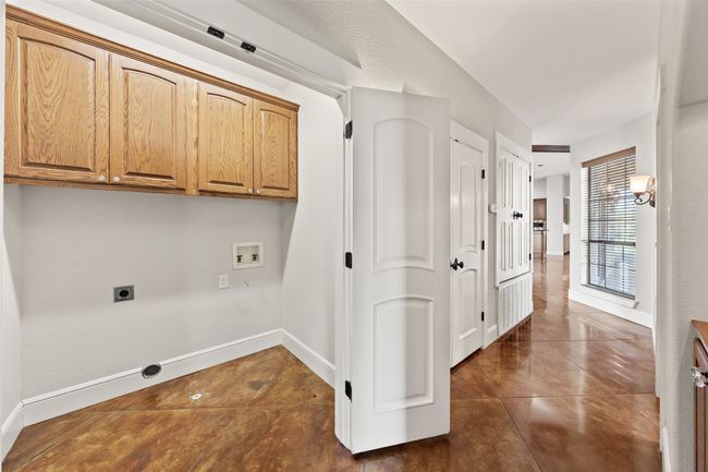 Washroom featuring cabinet space, washer hookup, hookup for an electric dryer, and dark tile patterned floors | Image 32