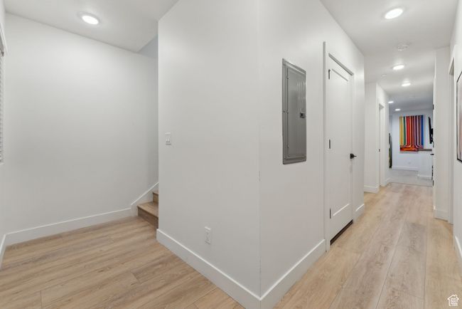 Hallway with light wood-type flooring and electric panel | Image 34