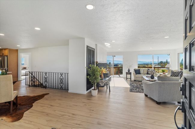 Living room featuring light hardwood /wood-style vinyl floors and a textured ceiling | Image 11