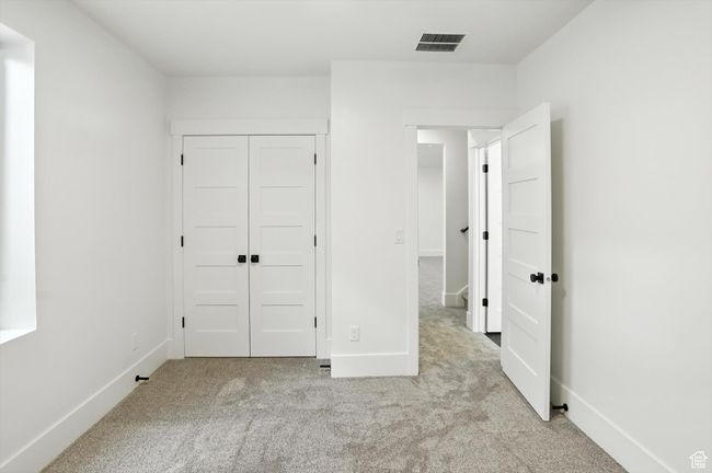 Unfurnished bedroom with carpet flooring and a closet | Image 35