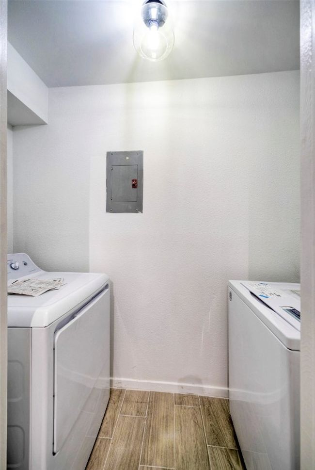 Washroom with electric panel, separate washer and dryer, and wood tiled floors | Image 10