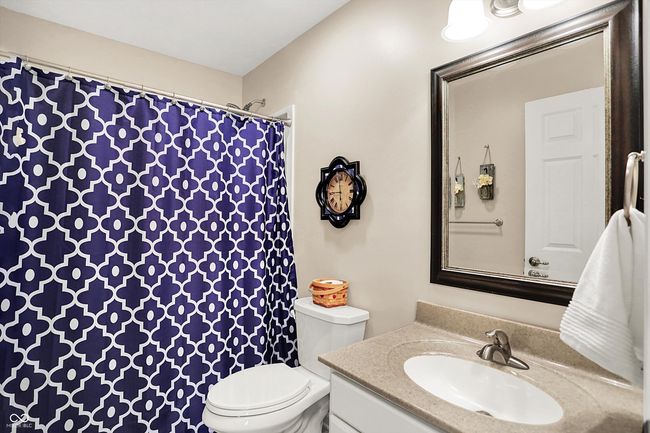 bathroom with toilet, vanity, and a shower with shower curtain | Image 31