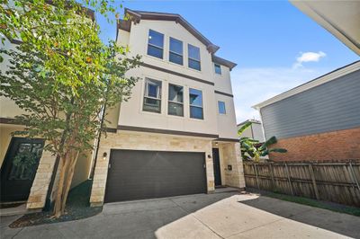 This free-standing, 3-story home features a charming stone and stucco façade with trim detailing. | Image 2