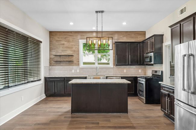 Kitchen featuring stainless steel appliances, a sink, dark brown cabinetry, backsplash, and recessed lighting | Image 8