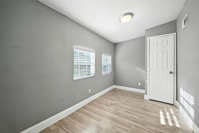 Unfurnished bedroom with baseboards and light wood-type flooring | Image 7