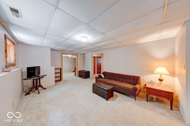 carpeted living area with a drop ceiling | Image 19