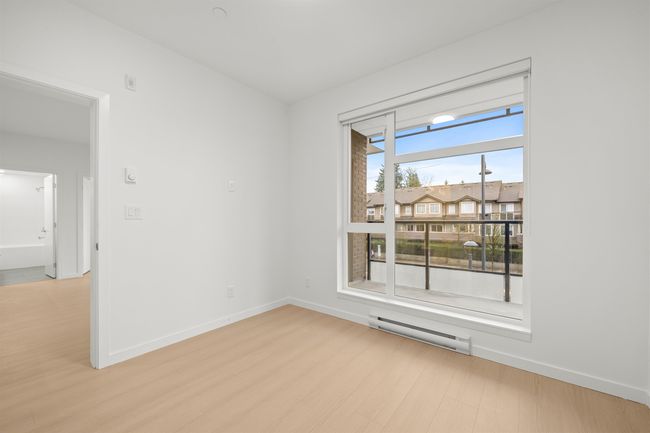 Empty room with baseboard heating and light wood-type flooring | Image 12