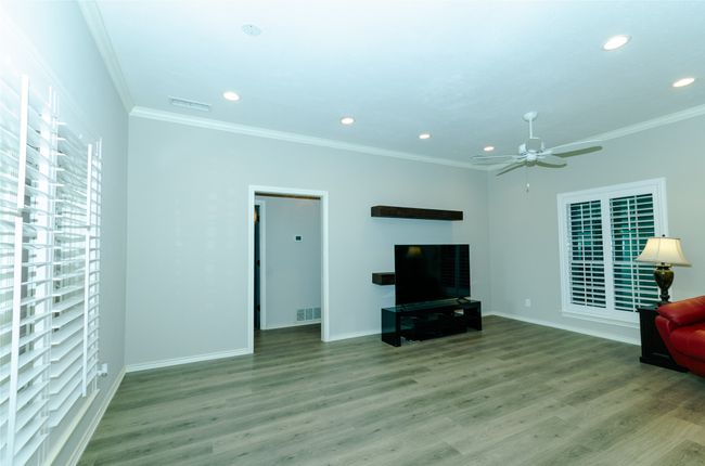 Unfurnished living room with ornamental molding, a ceiling fan, light wood-type flooring, and recessed lighting | Image 6