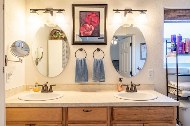 Full bathroom featuring double vanity, a textured wall, and a sink | Image 12