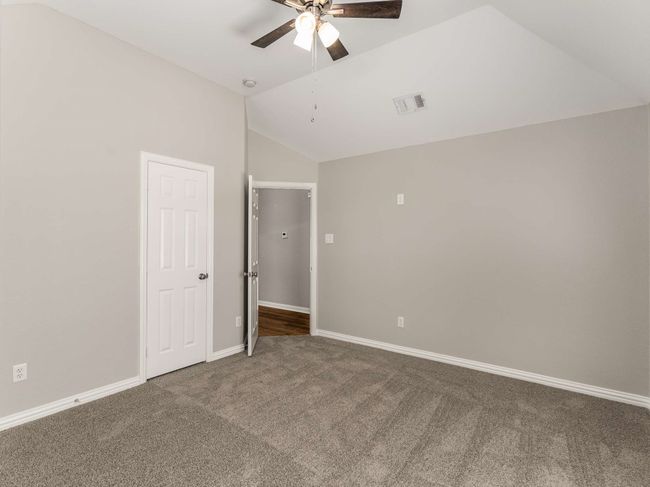 Carpeted empty room featuring baseboards, ceiling fan, and vaulted ceiling | Image 36