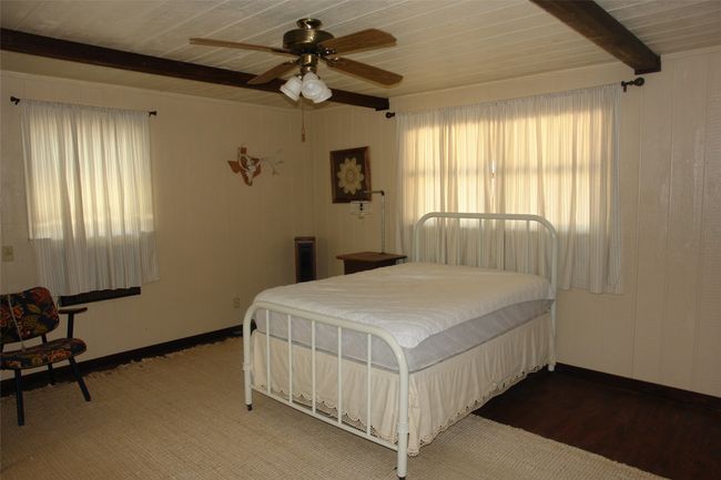Bedroom featuring wood ceiling, ceiling fan, wood-type flooring, and beam ceiling | Image 16