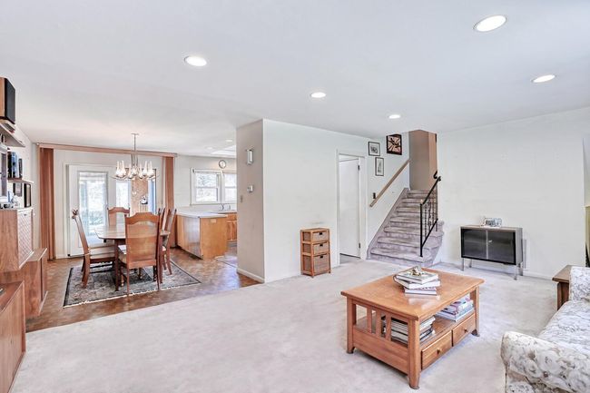 Living area with stairs, baseboards, recessed lighting, and a chandelier | Image 4