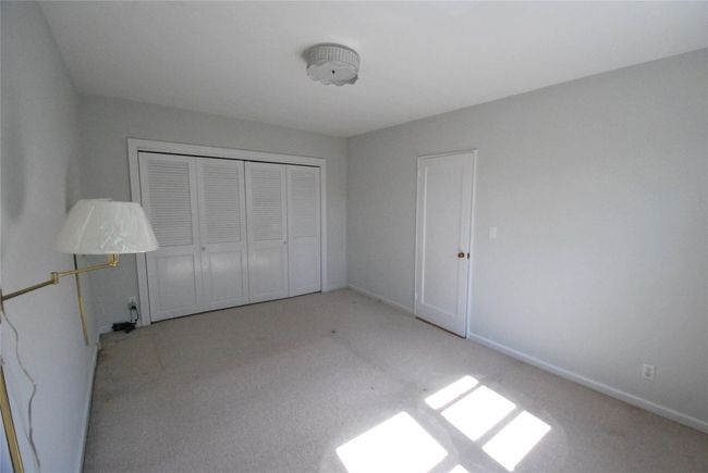 Unfurnished bedroom with burber carpet, a closet, and baseboards | Image 13