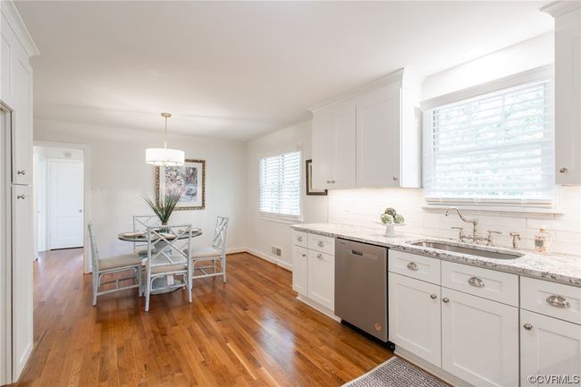 Kitchen featuring large breakfast room, granite countertops, stainless steel appliances, tiled backsplash, soft-close cabinetry, and refinished hardwood flooring | Image 10