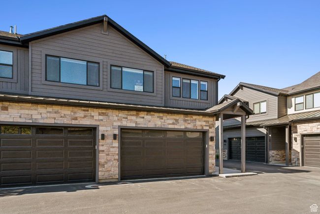 View of property featuring stone siding and an attached garage | Image 50