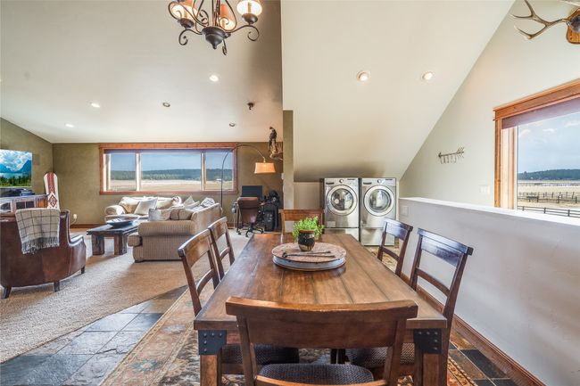 Caretaker Quarters / Guest House. Dining area, a chandelier, lofted ceiling, stone tile floors, and recessed lighting | Image 68