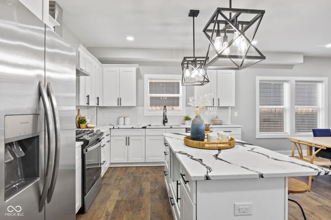 kitchen with a sink, white cabinetry, dark wood finished floors, appliances with stainless steel finishes, and recessed lighting | Image 10