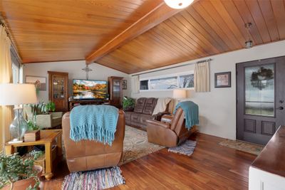 Living room featuring vaulted ceiling with beams, dark hardwood / wood-style flooring, wooden ceiling, and a healthy amount of sunlight | Image 3