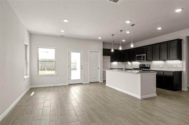 Kitchen with appliances with stainless steel finishes, recessed lighting, light wood-style flooring, a center island with sink, and pendant lighting | Image 11