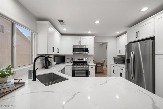 The gourmet chef’s kitchen is a masterpiece with quartz countertops, a touch-activated faucet, new sink, custom cabinetry, & premium stainless steel appliances. | Image 14