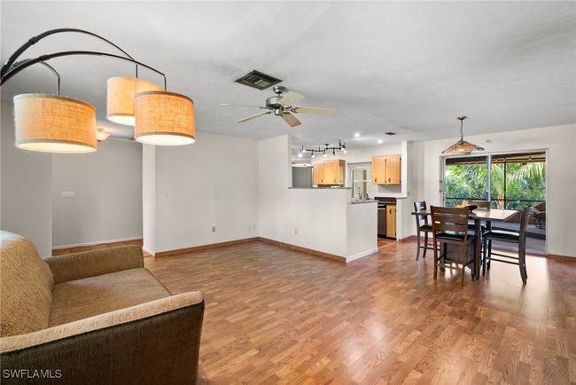 Living room featuring light wood-type flooring, rail lighting, and ceiling fan | Image 5