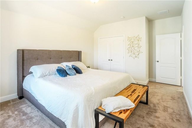 Bedroom featuring light colored carpet and vaulted ceiling | Image 25