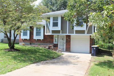 View of front of home with a front yard and a garage | Image 1