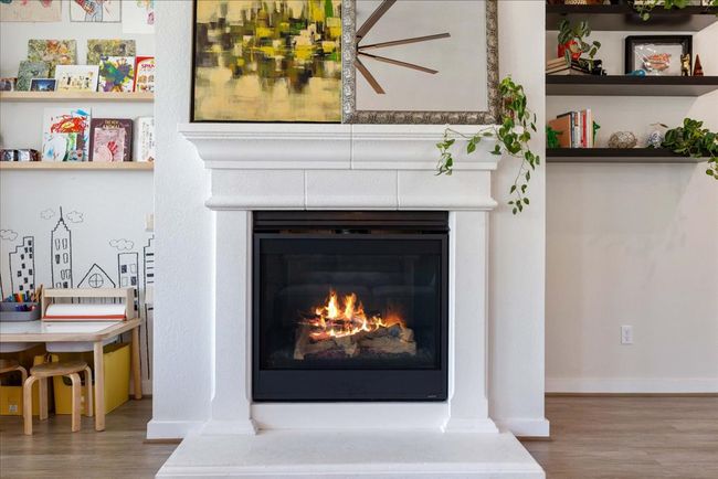 Details featuring baseboards, a glass covered fireplace, and wood finished floors | Image 14