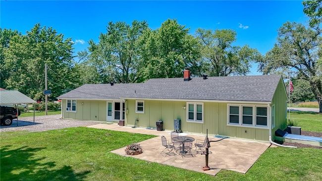 Rear view of property featuring a yard, board and batten siding, and a shingled roof | Image 41