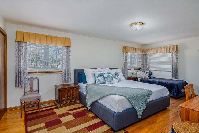 Bedroom featuring multiple windows, wood finished floors, and baseboards | Image 26