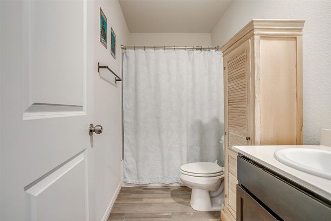 Bathroom featuring vinyl floors, vanity, and curtained shower | Image 21