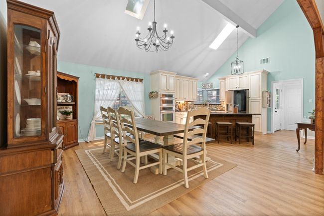 Dining space with a chandelier, high vaulted ceiling, light wood finished floors, and beamed ceiling | Image 10