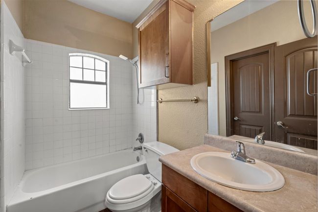 Full bathroom featuring vanity, shower combination, and a textured wall | Image 12