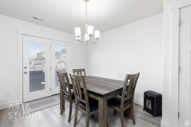 Dining room with visible vents, baseboards, an inviting chandelier, and light wood-style flooring | Image 12