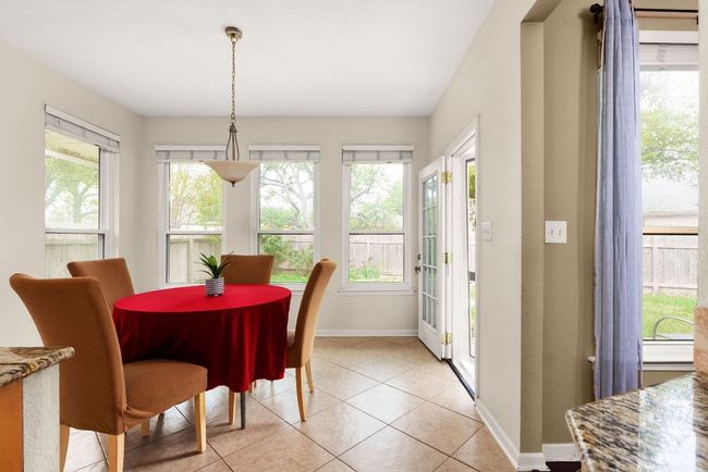 Dining area featuring light tile patterned floors and baseboards | Image 12