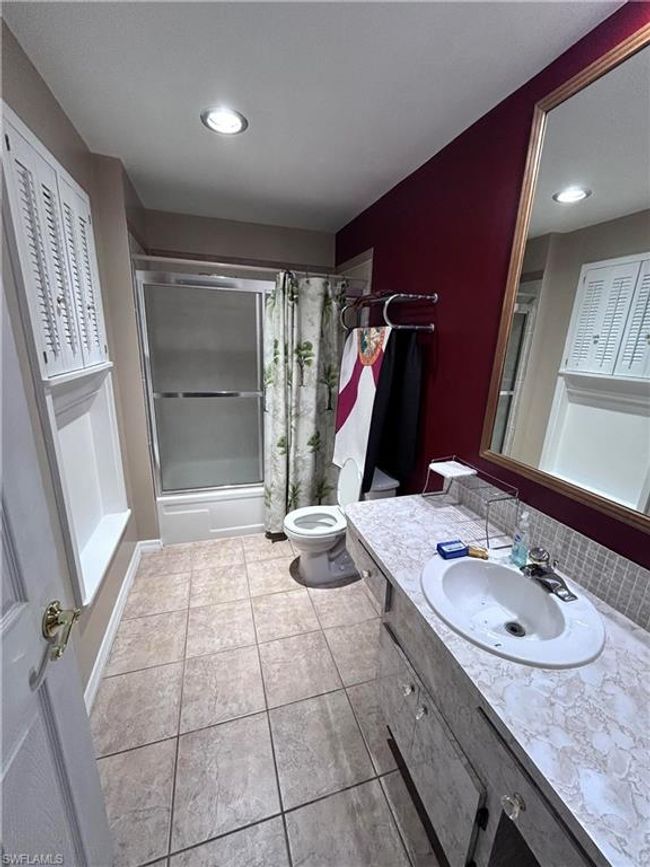 Full bathroom with tile patterned flooring, vanity, toilet, and combined bath / shower with glass door | Image 14