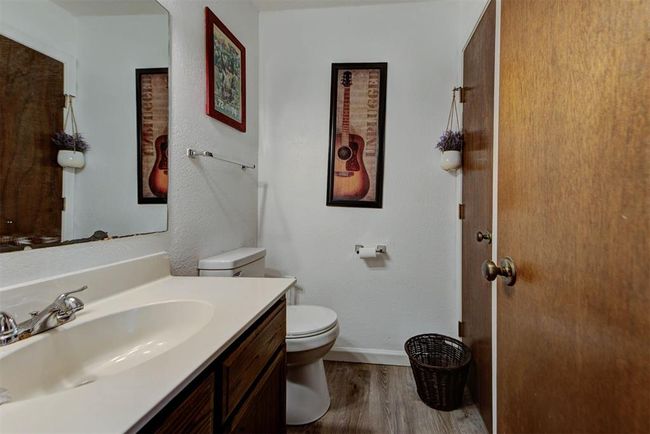 Bathroom featuring wood finished floors, toilet, vanity, and baseboards | Image 11