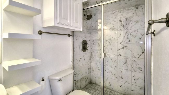 Bathroom with toilet and an enclosed shower | Image 23