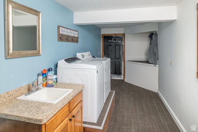 Washroom featuring separate washer and dryer, sink, and a textured ceiling | Image 30
