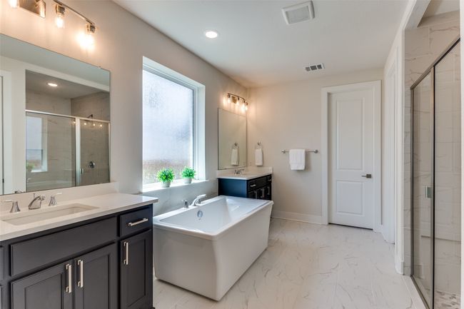 Full bathroom with marble finish floors, a shower stall, two vanities, a freestanding tub, and recessed lighting | Image 22