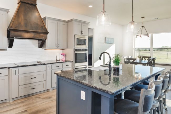 Kitchen with decorative backsplash, recessed lighting, custom range hood, a sink, and appliances with stainless steel finishes | Image 7