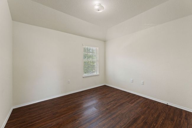 Empty room with dark wood-style flooring and vaulted ceiling | Image 18
